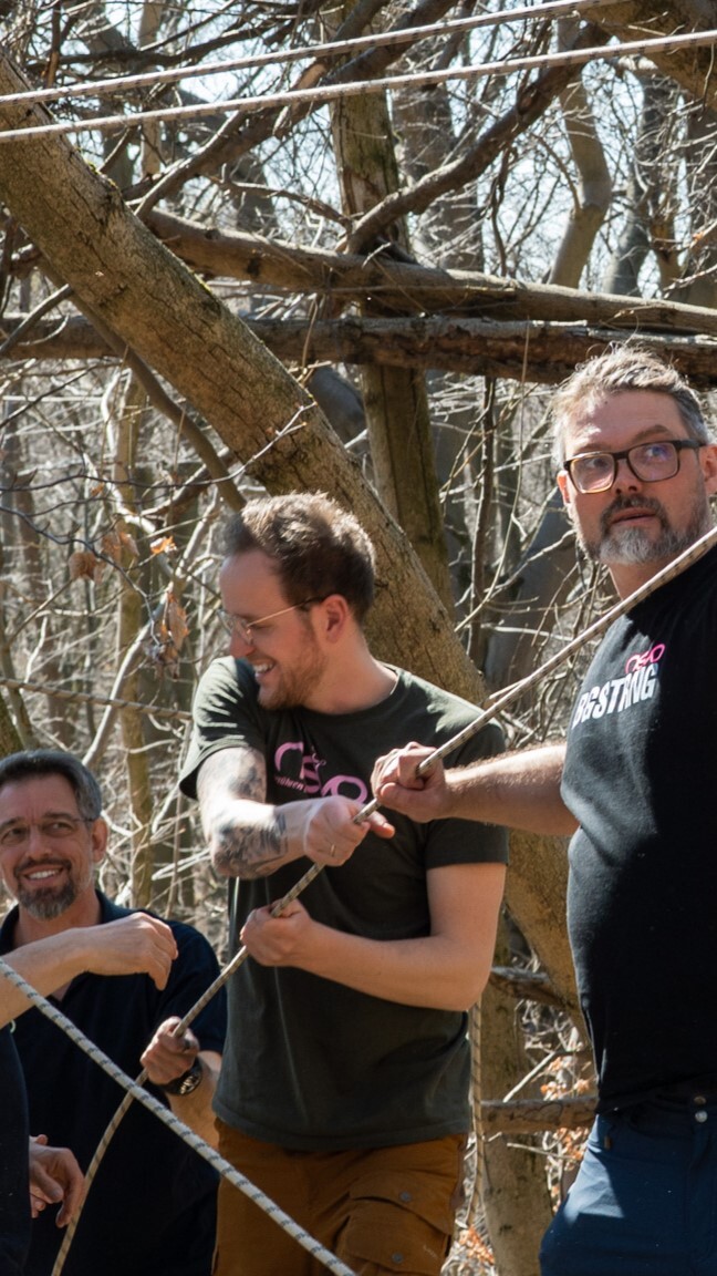 "Nevo Team baut eine Seilrutsche auf und zieht gemeinsam an einem Kletterseil"